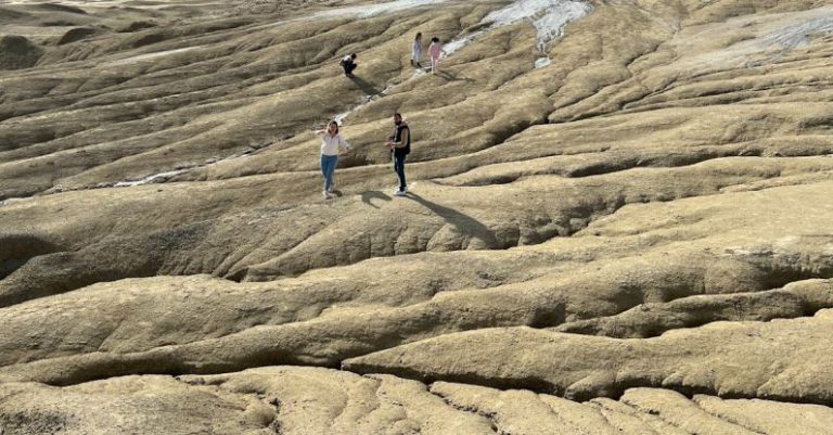 Nature Hike - People walking on a rocky terrain with mountains in the background