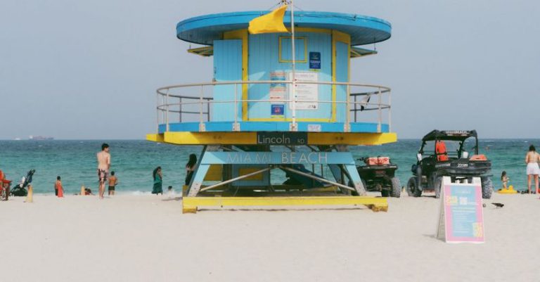 Safety Tips - A lifeguard tower on the beach with people walking by