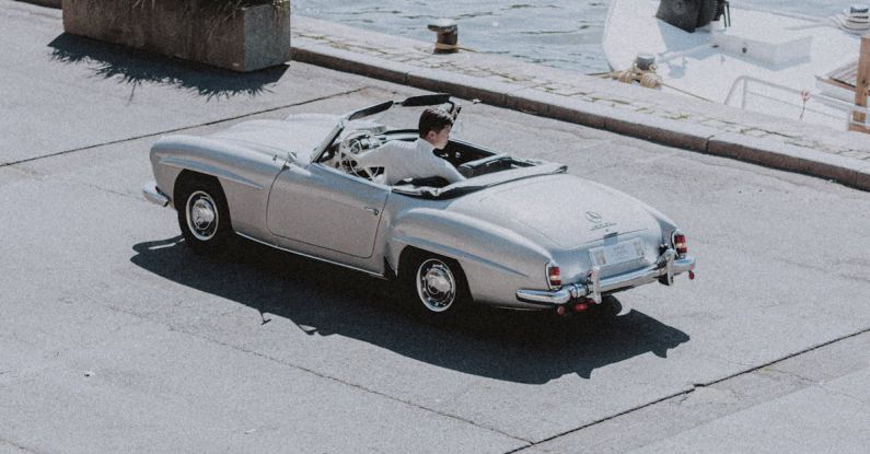 Weekend Drive - Old silver car driving on road