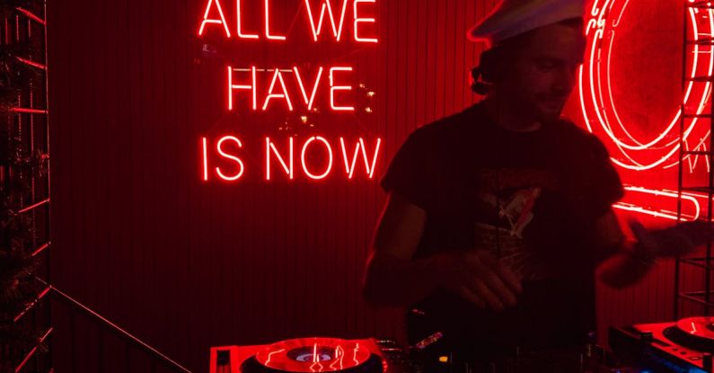 Popular Festivals - DJ performing music near signboard all we have is now