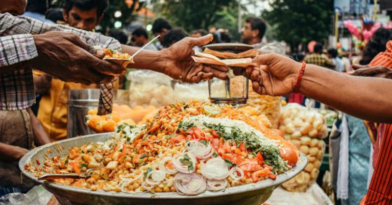 Festival Passes - Man Passing Food to Another Person on a Street Food Festival